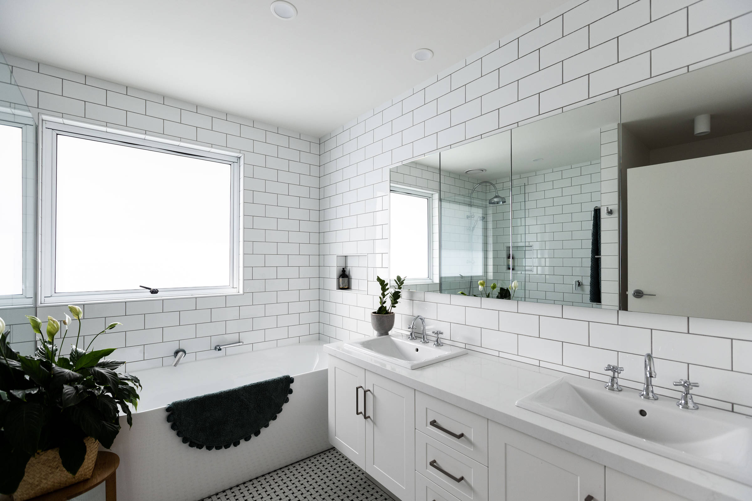 Bathroom renovation featuring white subway tiles and an Italian tile floor with a light, bright contemporary finish. Photo: Jordan Davis.