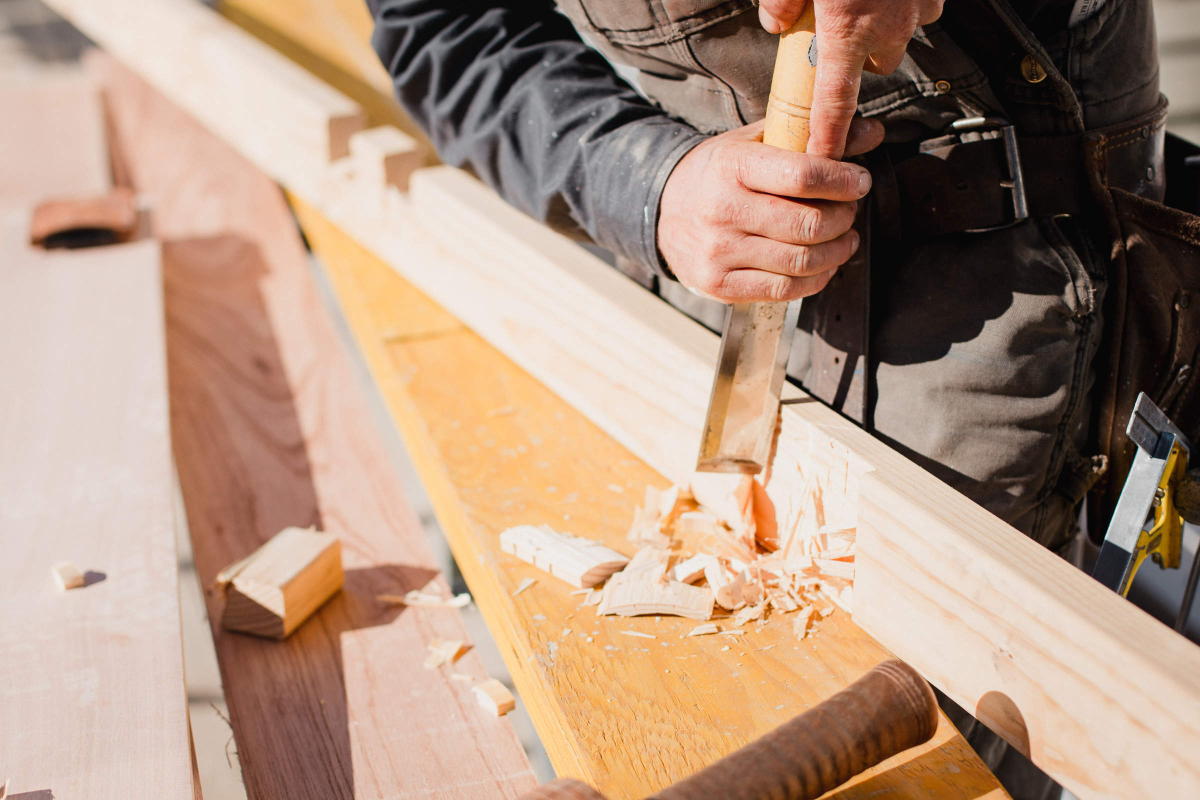 Hand crafting timber framing with chisel for custom renovation. Photo: Jordan Davis.